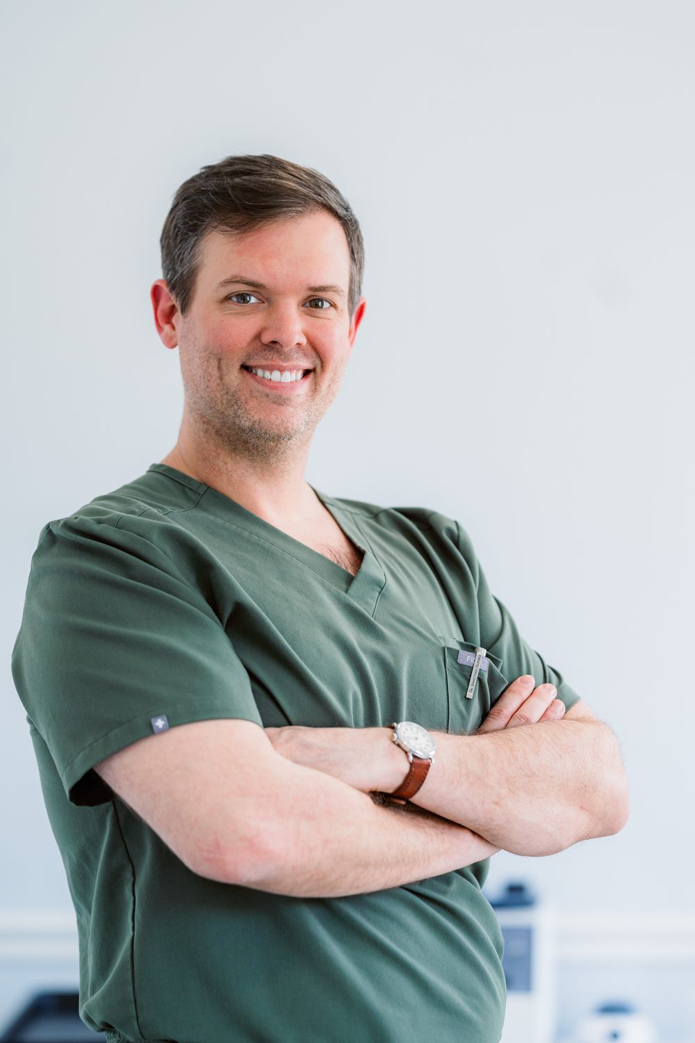 Smiling healthcare professional in scrubs.