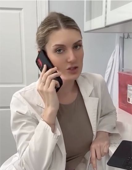 Woman in lab coat talking on the phone.