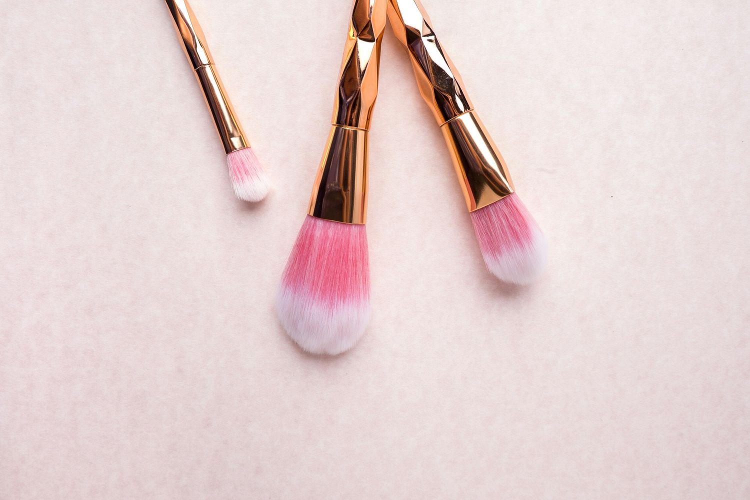 Pink makeup brushes on a soft background.