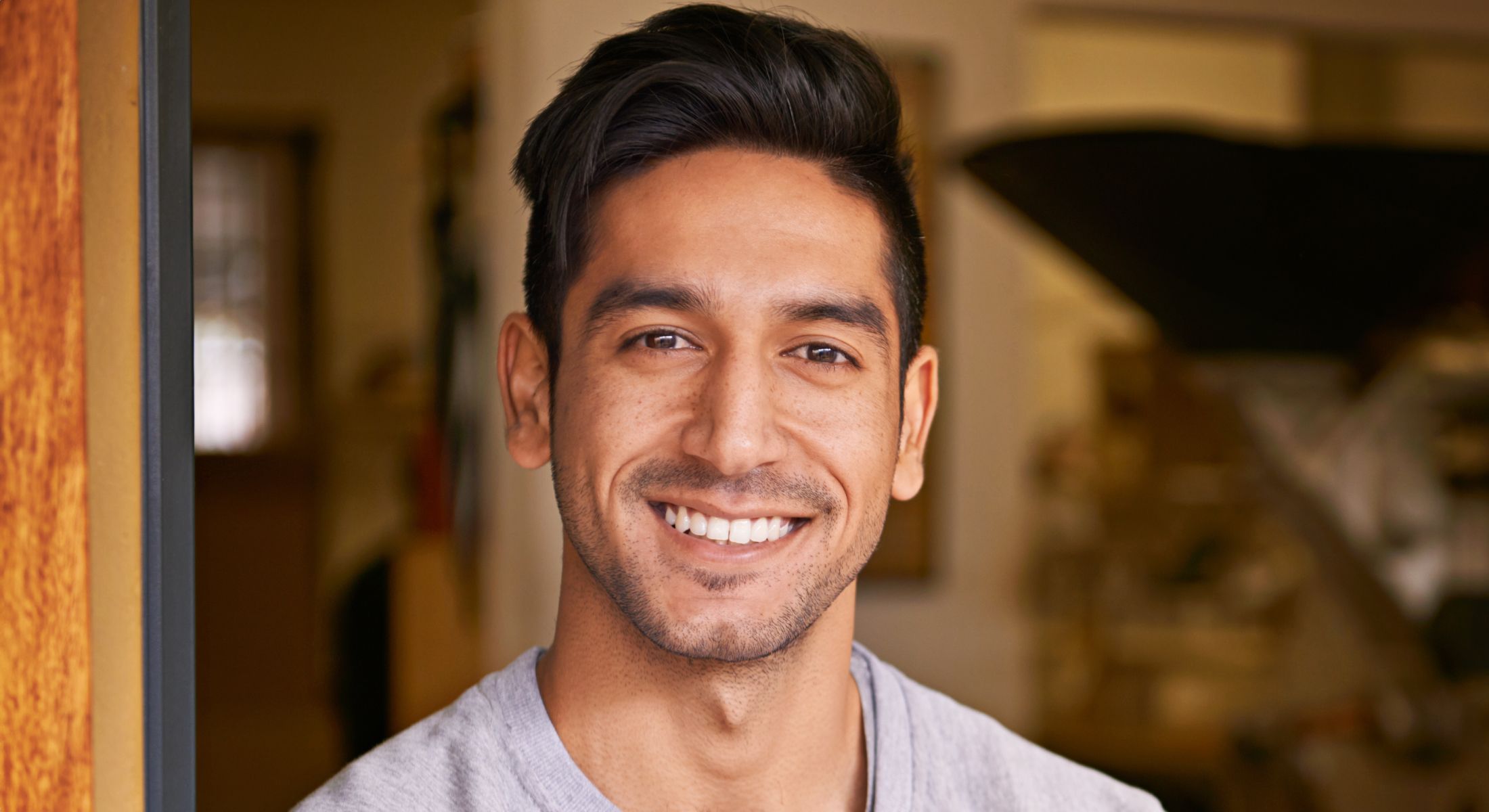 Smiling Hinsdale hair restoration model standing in doorway.