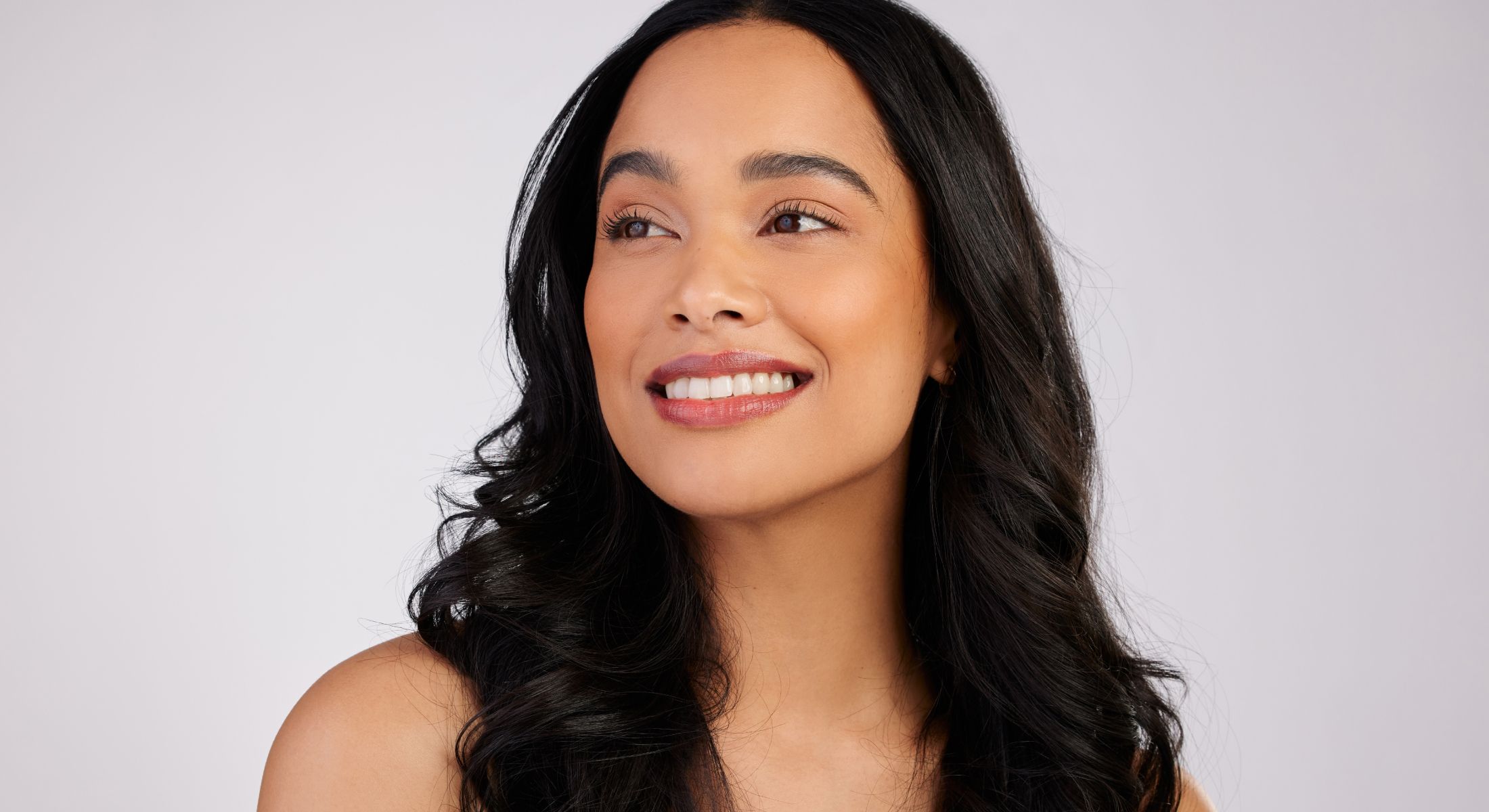 Smiling woman with long, wavy black hair.