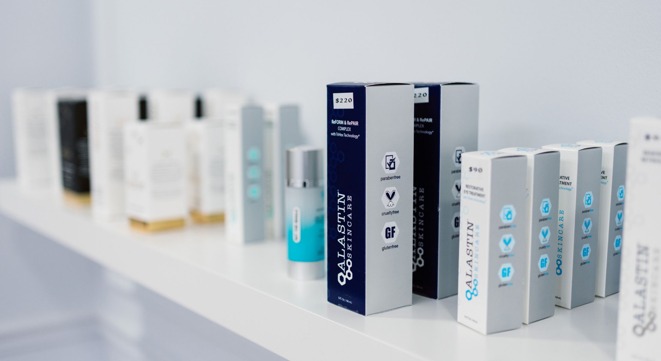 Skincare products displayed on a white shelf.